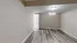 Spacious room with elegant light wood flooring and neutral walls, featuring a door leading to another area.