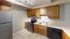 Inviting kitchen with wooden cabinets, modern appliances, and sleek tile flooring.