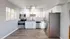 Bright, contemporary kitchen with stainless steel appliances, white cabinetry, and wood flooring.
