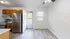 Bright kitchen with stainless steel refrigerator, wooden cabinets, and light wood flooring.