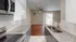 Modern kitchen with granite countertops, stainless steel appliances, and an open living room.