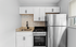 Modern kitchen design with sleek stainless steel appliances, elegant white cabinetry, and a chic subway tile backsplash.