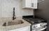 Contemporary kitchen showcasing elegant granite countertops, sleek stainless steel appliances, and modern backsplash tiles.