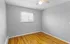 Bright, minimalist bedroom with gleaming hardwood floors and modern ceiling fan, perfect for creating a personalized sanctuary.