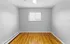 Bright and welcoming room with sleek hardwood floors, modern gray walls, and a large window overlooking a scenic view.