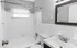 Bright and modern bathroom featuring a sleek vanity, elegant shower setup, and a classic bathtub.