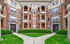 Elegant historic apartment building with charming brick facade, lush greenery, and welcoming entrances, offering classic architectural beauty and cozy living spaces.
