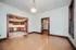 Inviting open-concept living area with warm wood flooring, a charming kitchen with wooden cabinetry, and ample natural light filtering through large windows.