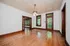 Charming living room with elegant wooden floors, bright natural light from tall windows, and classic wood trim detailing.