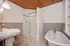 Charming bathroom with elegant clawfoot tub, modern glass shower, and warm wooden ceiling.