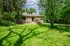 Charming home with a lush green lawn and mature trees, perfect for nature enthusiasts seeking tranquility.