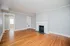 Bright and inviting living room with elegant hardwood floors, classic white fireplace, and soothing gray walls.