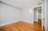 Bright empty room with sleek hardwood flooring, fresh neutral walls, and modern lighting, perfect for personalization and comfort.