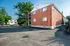 Charming brick apartment building with ample parking and lush green surroundings, perfect for city living.