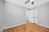 Freshly painted room with elegant gray walls, rich hardwood floors, and a sleek ceiling fan.