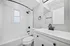 Sleek modern bathroom featuring elegant white subway tiles, a stylish vanity, and contemporary black fixtures.
