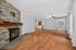 Elegant living room with warm hardwood floors, a stylish stone fireplace, and abundant natural light.