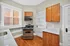 Charming kitchen with modern appliances, elegant wood cabinets, and gleaming hardwood floors drenched in natural light.
