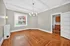 Bright, spacious living area with elegant hardwood flooring, modern light fixture, and large window for natural light.
