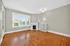 Charming living room with elegant hardwood flooring, a cozy fireplace, and large windows offering abundant natural light.