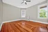 Bright and inviting room with sleek hardwood flooring and large windows offering a view of lush greenery.