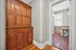 Charming hallway with vintage wooden cabinet leading to a bright bathroom with stylish tile flooring.