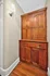 Charming corner with elegant wooden cabinetry and classic wall sconce lighting, adding warmth and character.
