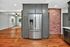 Contemporary open-concept kitchen featuring stainless steel appliances, elegant gray cabinetry, and a charming exposed brick accent in a bright, spacious living area.