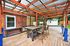 Charming outdoor patio with rustic wooden pergola, stylish dining set, and vibrant natural surroundings.