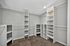 Spacious walk-in closet with built-in shelves and ample storage space, perfect for organizing.