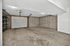Expansive two-car garage with sturdy shelving units, perfect for storage and workspace needs.