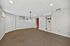 Cozy basement room with neutral carpet and modern lighting, perfect for a creative home office or stylish relaxation area.