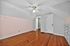Charming attic room with warm hardwood floors, built-in drawers, and elegant ceiling fan, leading to a spacious walk-in closet.