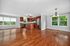 Inviting open-concept living space featuring elegant hardwood floors, a modern kitchen with stainless steel appliances, and large windows offering picturesque views.