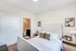 Bright modern bedroom featuring a plush bed with chic pillows, stylish decor, and an en-suite bathroom.