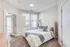 Bright and inviting bedroom with a cozy double bed, plush carpet, and large windows for natural light.