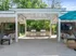 Elegant outdoor lounge area with modern grills and cozy seating under a stylish pergola, perfect for entertaining.
