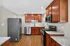 Modern kitchen with sleek stainless steel appliances, warm wood cabinets, and elegant granite countertops.