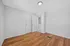 Bright, modern room with sleek hardwood flooring, ample natural light, and elegant double doors. A sophisticated space perfect for a cozy bedroom or a stylish home office.