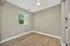Bright and inviting room featuring elegant hardwood flooring, a modern ceiling fan, and a window with blinds offering a lush view.