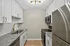 Modern kitchen showcasing sleek granite countertops, stainless steel appliances, and elegant white cabinetry with gold hardware.