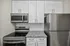 Modern kitchen with sleek stainless steel appliances, elegant granite countertops, and pristine white cabinetry.