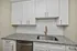Modern kitchen design with sleek white cabinetry, granite countertops, and elegant brass fixtures.