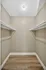 Spacious walk-in closet with sleek wooden flooring and ample hanging space, perfect for organizing a modern wardrobe.
