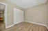 Charming empty room with sleek hardwood floors, neutral-toned walls, and a spacious closet. Perfect for customization and modern living.
