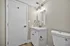 Sleek modern bathroom featuring elegant gold fixtures, a chic vanity with a large mirror, and a pristine white toilet.