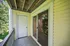 Charming balcony with rustic wooden railing and serene garden view, perfect for relaxation.