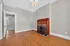 Charming living room with elegant hardwood floors, a classic brick fireplace, and bright natural light.