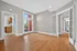 Charming apartment with elegant hardwood floors, natural light through French doors, and a view of the patio.