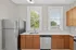 Bright, modern kitchen with stainless steel appliances, elegant cabinets, and large windows offering abundant natural light.